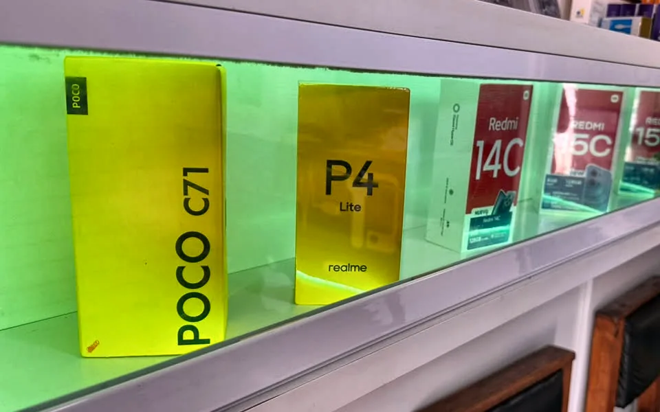 Vitrine iluminada da loja com caixas de celulares POCO, realme e Redmi